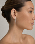 Female model wearing 14K Bridal Small Graduated Baguette Tear Drop Earrings