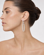 Female model wearing 14K Oval Chain Dangling Diamond Earrings