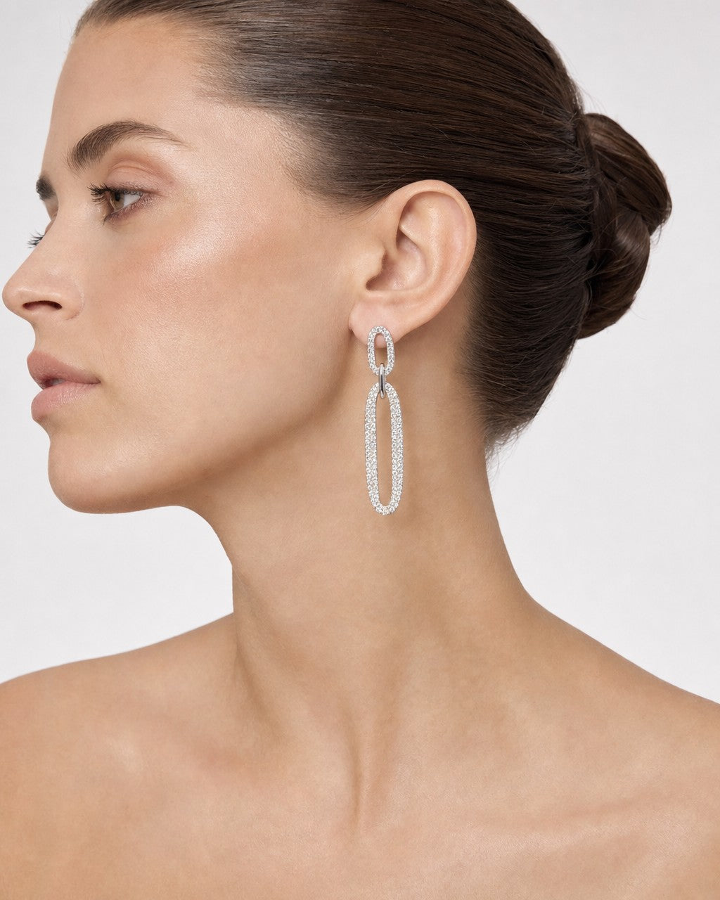 Female model wearing 14K Oval Chain Dangling Diamond Earrings