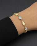 Male model wearing 14K 5.8MM Two-Tone Flat Oval Ball Link Bracelet 7.5"