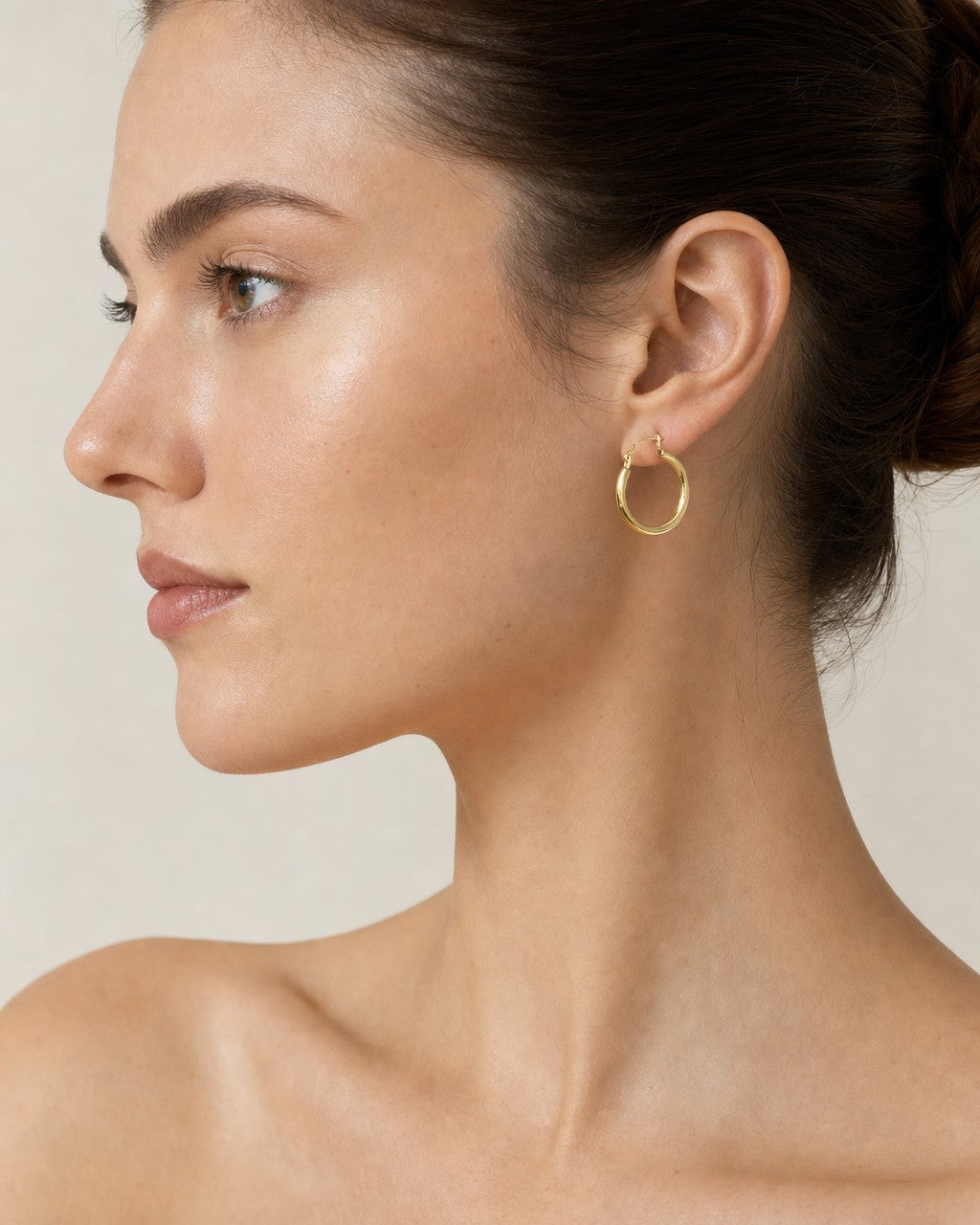 Female model wearing 14K Bold Tube Hoop Earrings