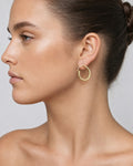 Female model wearing 14K Flat Tube Hoop Earrings