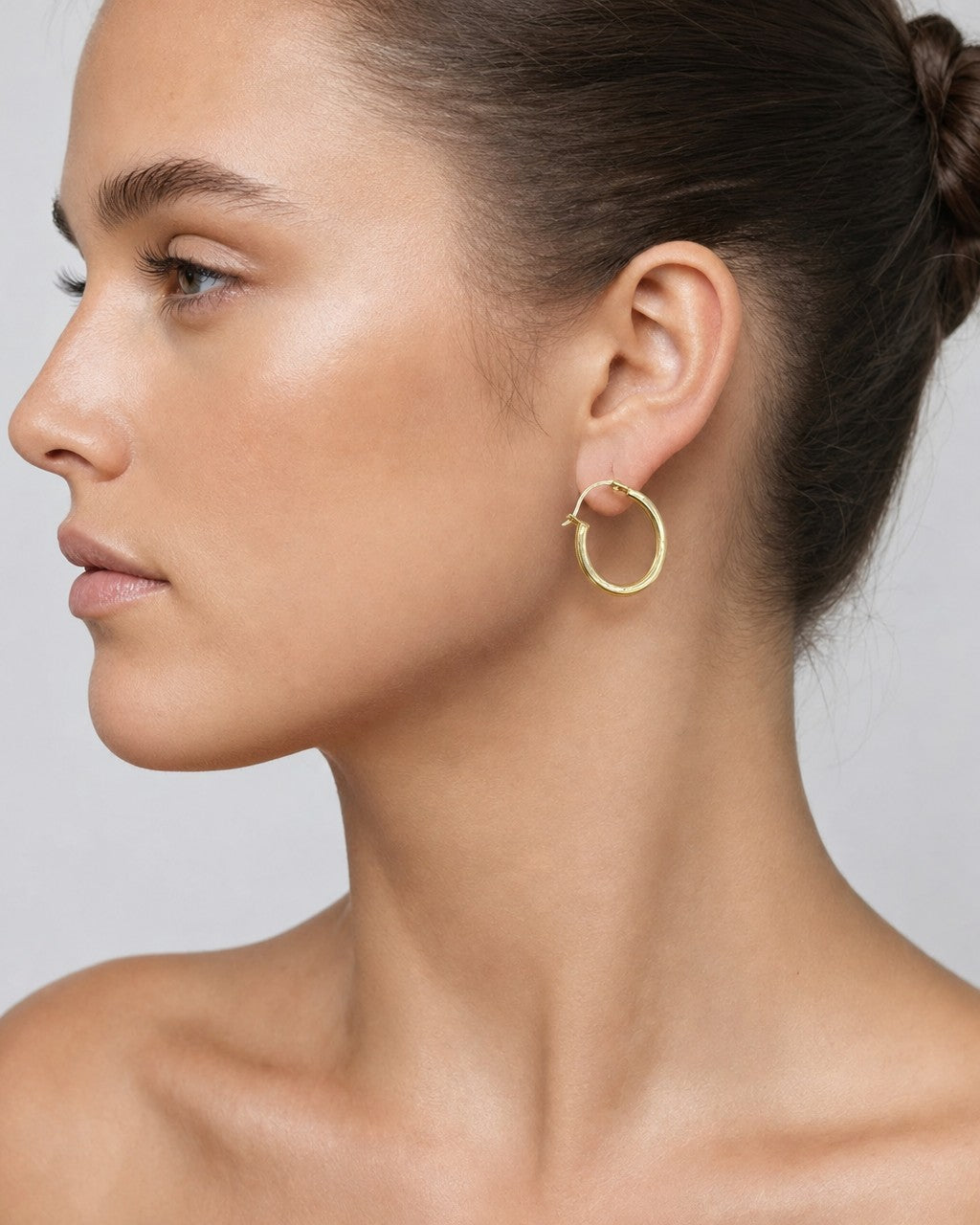 Female model wearing 14K Flat Tube Hoop Earrings