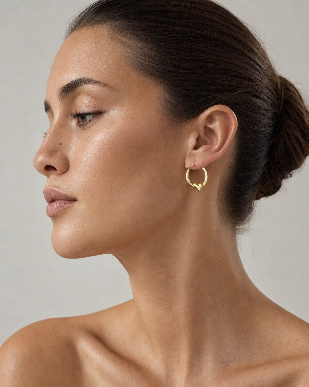 Female model wearing 14K Puff Heart Hoop Earrings