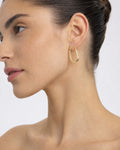 Female model wearing 14K Morning Star Oval Hoop Earrings
