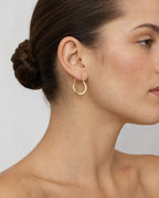 Female model wearing 14K Medium Hoop Earrings