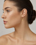 Female model wearing 14K Cross Hoop Earrings