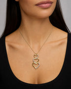 Female model wearing 10K Heart Charm Stack Diamond Pendant