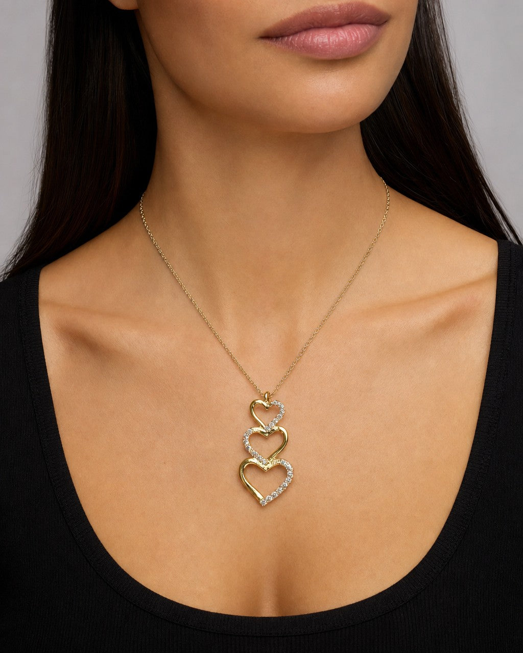 Female model wearing 10K Heart Charm Stack Diamond Pendant