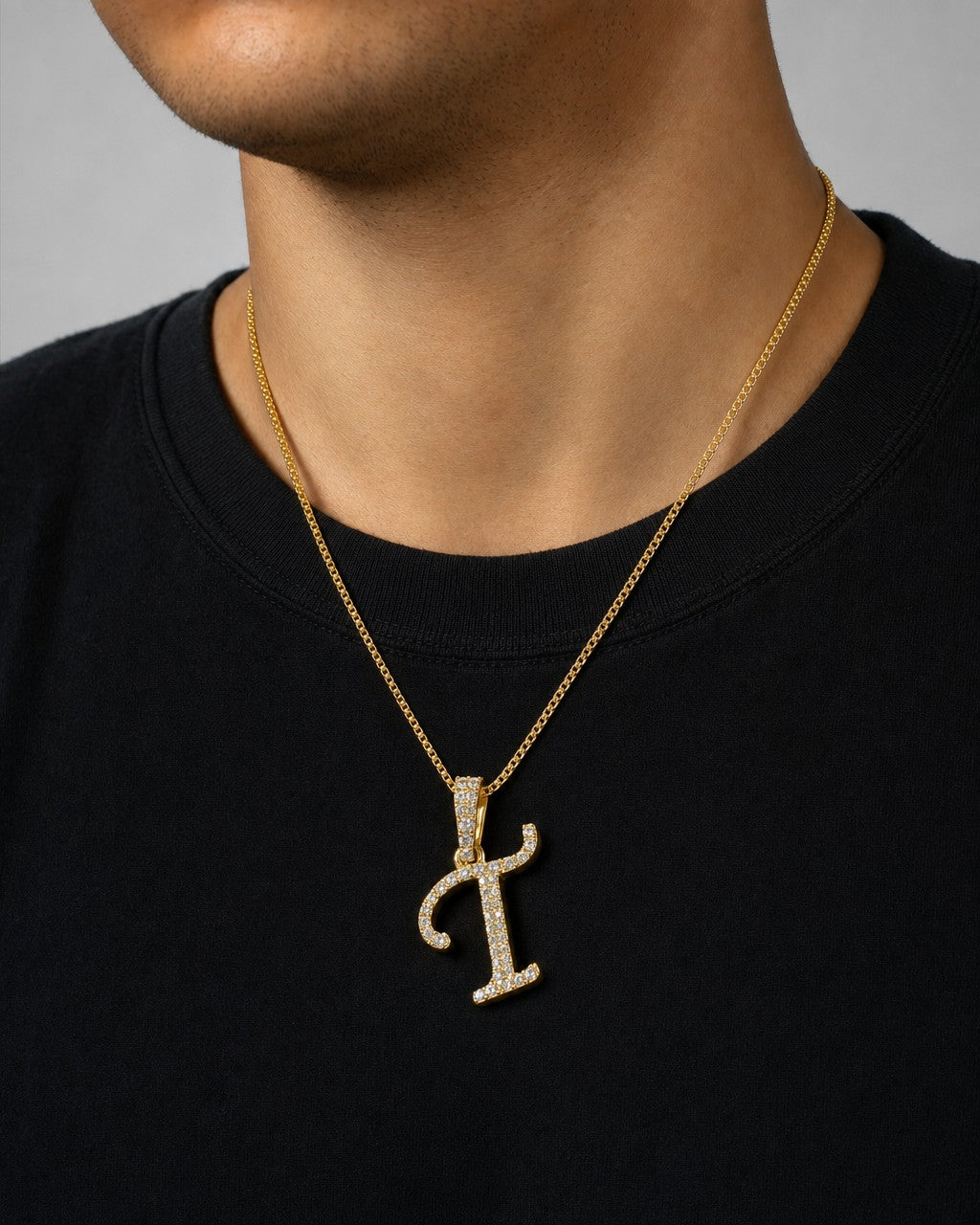 Male model wearing 10K Cursive T Initial Diamond Pendant