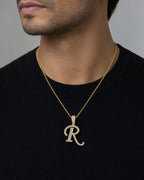 Male model wearing 10K Cursive R Initial Diamond Pendant