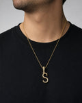 Male model wearing 10K Cursive S Initial Diamond Pendant