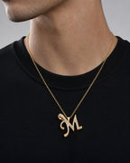 Male model wearing 10K Cursive M Initial Diamond Pendant