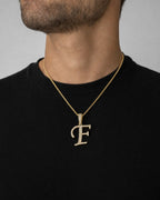 Male model wearing 10K Cursive F Initial Diamond Pendant