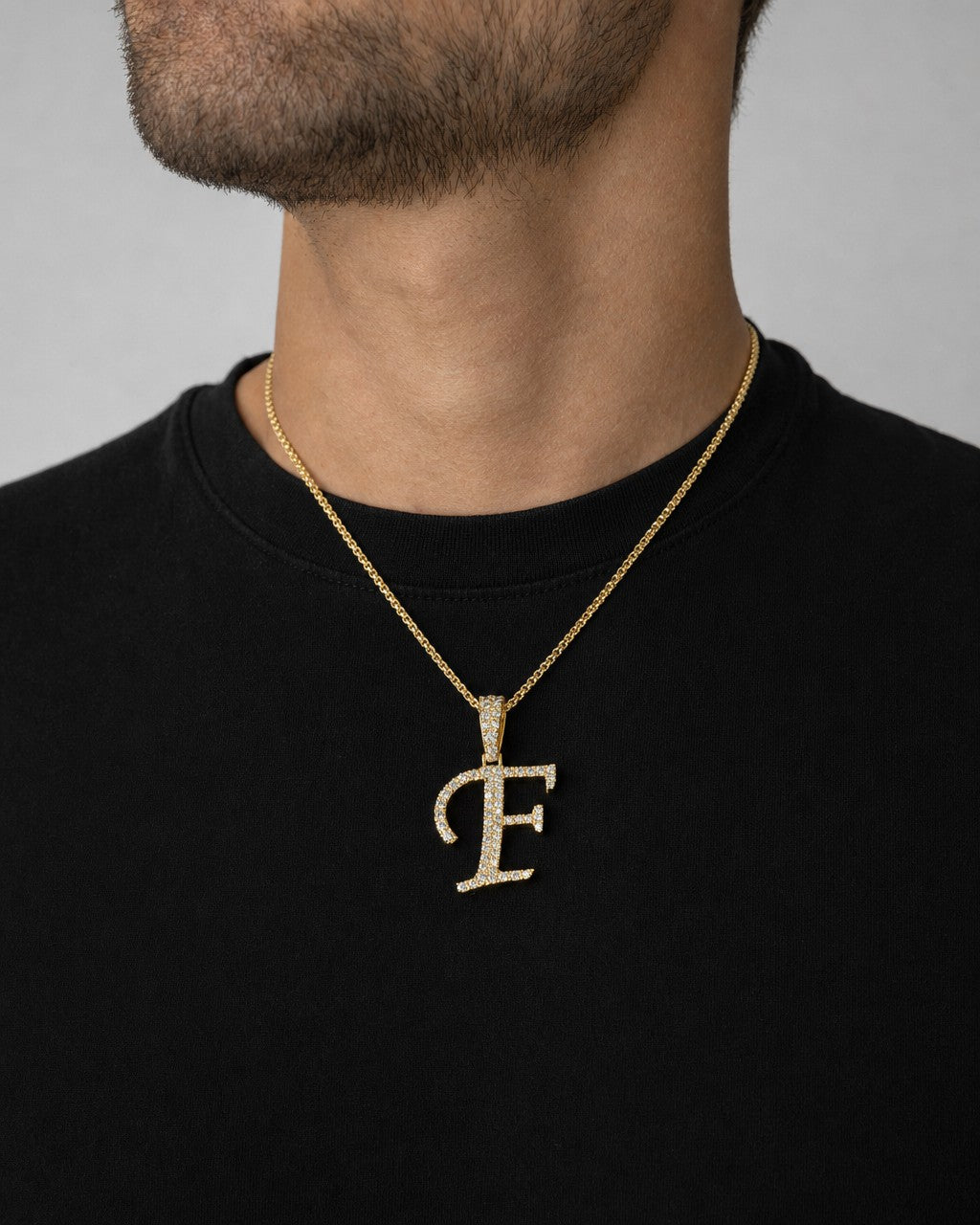 Male model wearing 10K Cursive F Initial Diamond Pendant