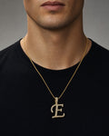 Male model wearing 10K Cursive E Initial Diamond Pendant