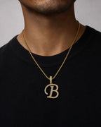 Male model wearing 10K Cursive B Initial Diamond Pendant