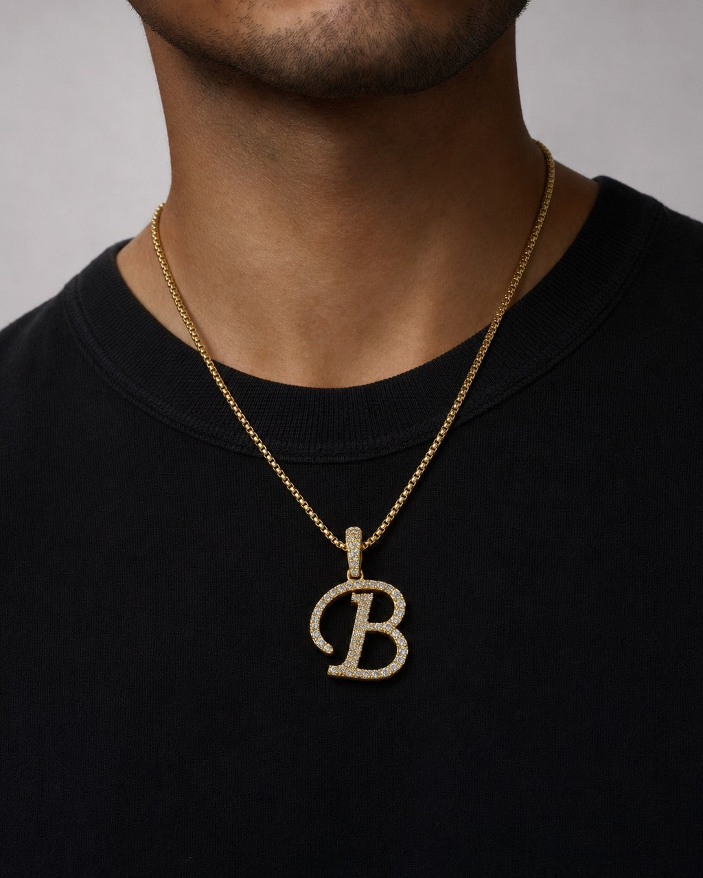 Male model wearing 10K Cursive B Initial Diamond Pendant