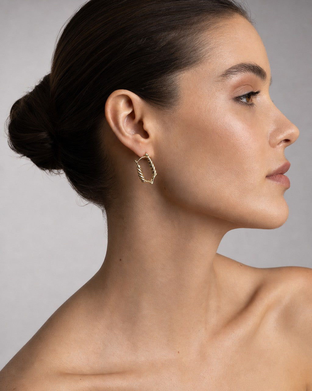 Female model wearing 10K Braided Rectangle Hoop Earrings