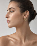 Female model wearing 10K Flat Croissant Hoop Earrings