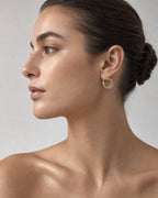 Female model wearing 10K Flat Croissant Hoop Earrings