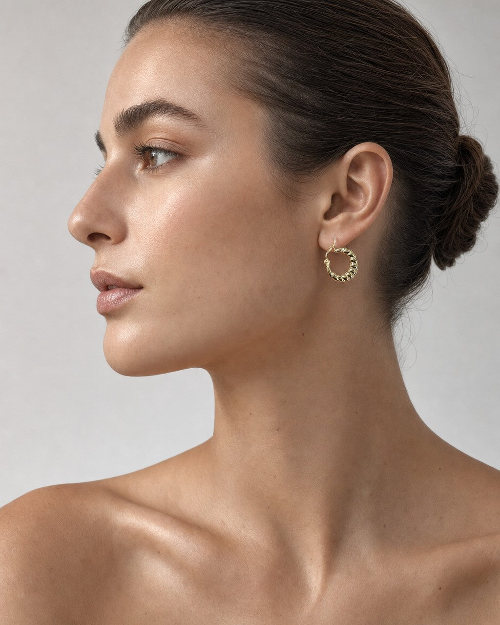 Female model wearing 10K Flat Croissant Hoop Earrings