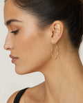 Female model wearing 14K Gold Large 2MM Hoop Earrings