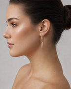 Female model wearing 14K Gold Medium 2MM Hoop Earrings