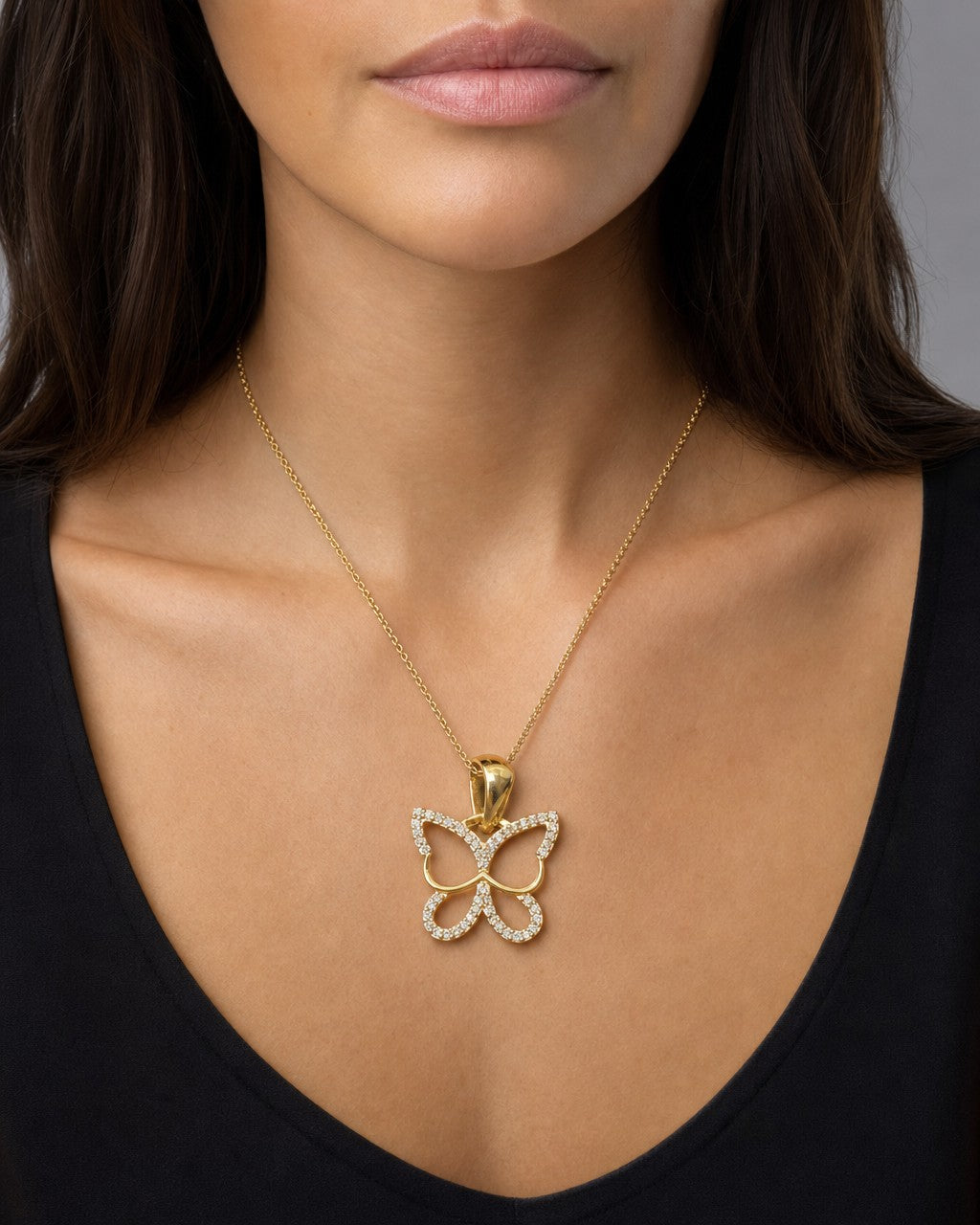 Female model wearing 10K Butterfly Outline Pendant