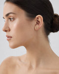 Female model wearing 14K Cross Diamond Earrings