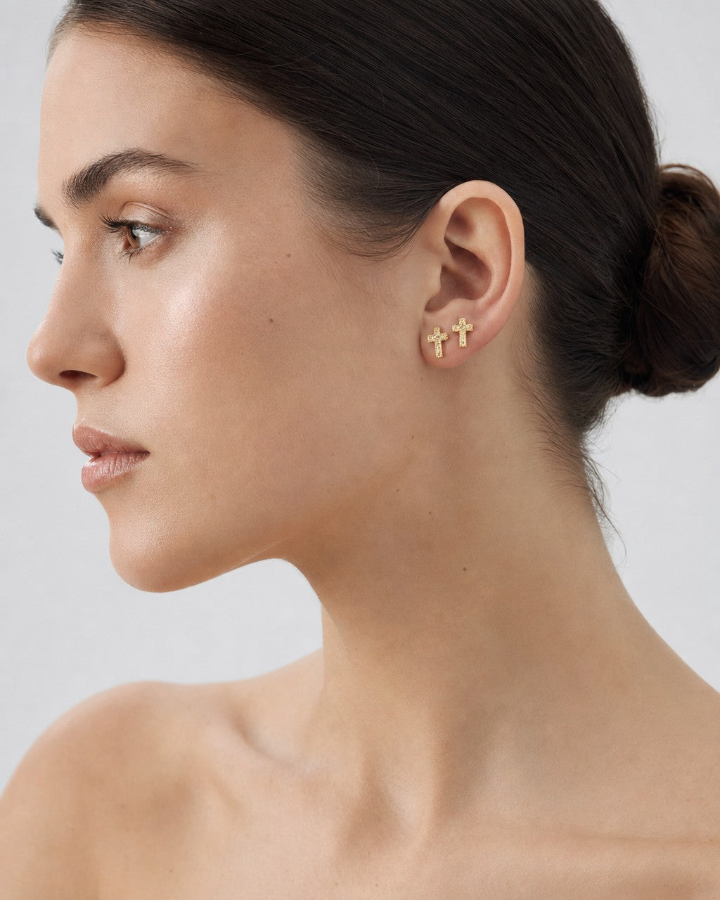 Female model wearing 14K Cross Diamond Earrings